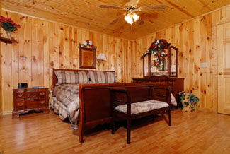The bedroom with floor to ceiling wood with a dresser.